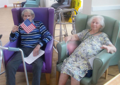 Two seated residents, one holding an American flag