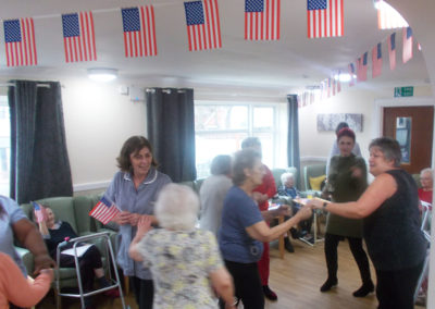 Staff and residents dancing together in the lounge