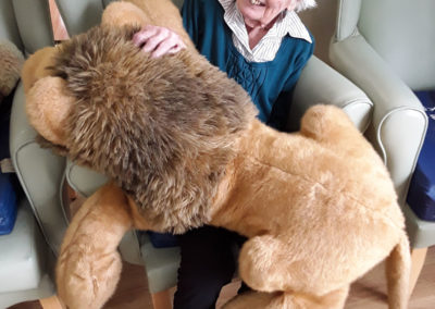 Resident cuddling with a soft toy lion