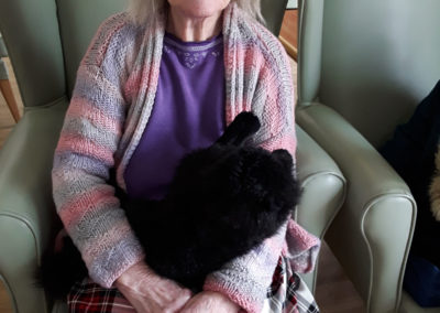 Resident cuddling with a soft toy black cat