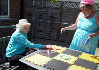 Sonya Lodge Residential Care Home resident playing a game of giant noughts and crosses with Administrator Amanda