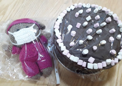 Crocheted carer and chocolate cake covered in marshmallows