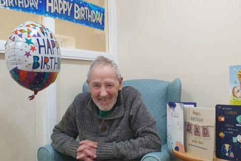 Male resident smiling to the camera on his birthday at Sonya Lodge Residential Care Home