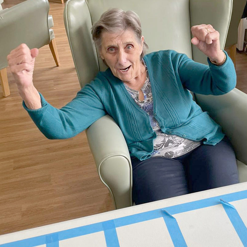 Sonya Lodge Residential Care Home resident cheering at winning a dice game