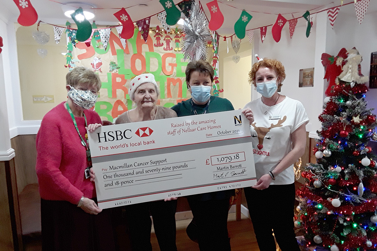 Sonya Lodge Residential Care Home team and MacMillan representative with charity cheque