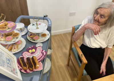 Sonya Lodge Residential Care Home resident enjoying by an Alice in Wonderland afternoon tea trolley