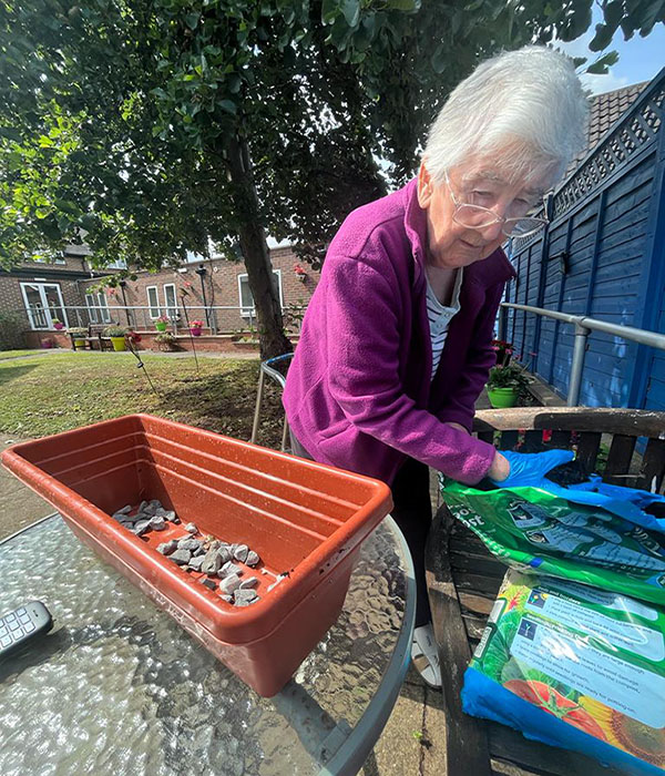 Sonya Lodge Residential Care Home resident Angela planting seeds 