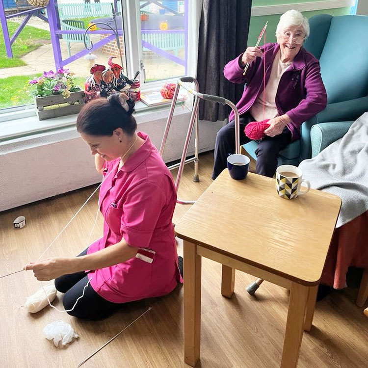 Sonya Lodge Residential Care Home resident and team member knitting together
