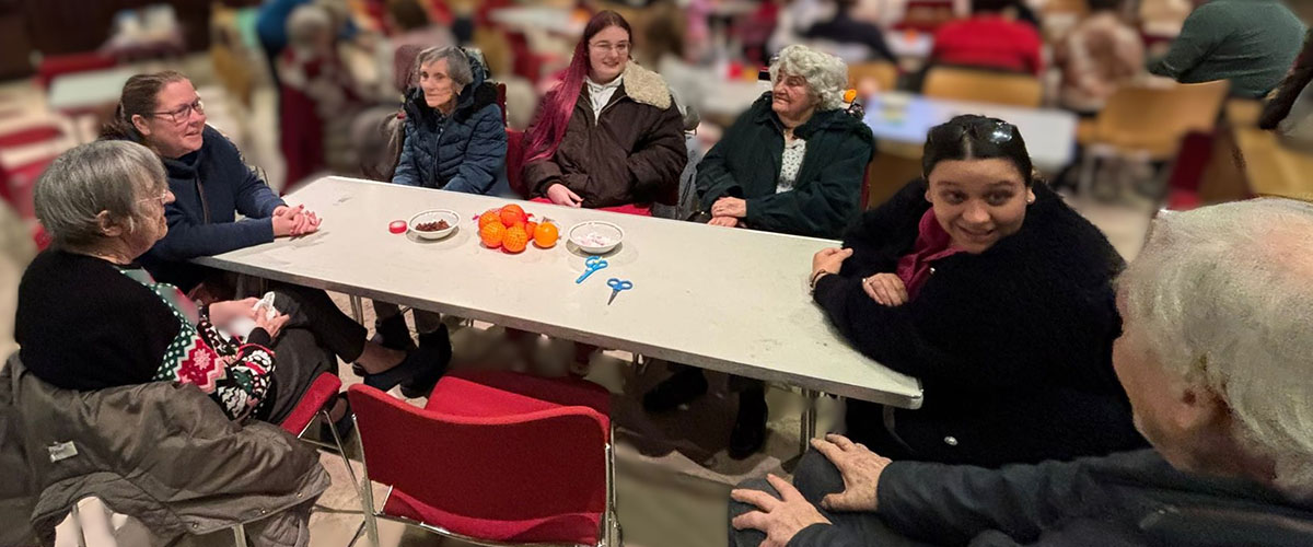 Sonya Lodge residents chatting and laughing with friends during the Christingle service at St Michael’s of All Angels Church in Wilmington.